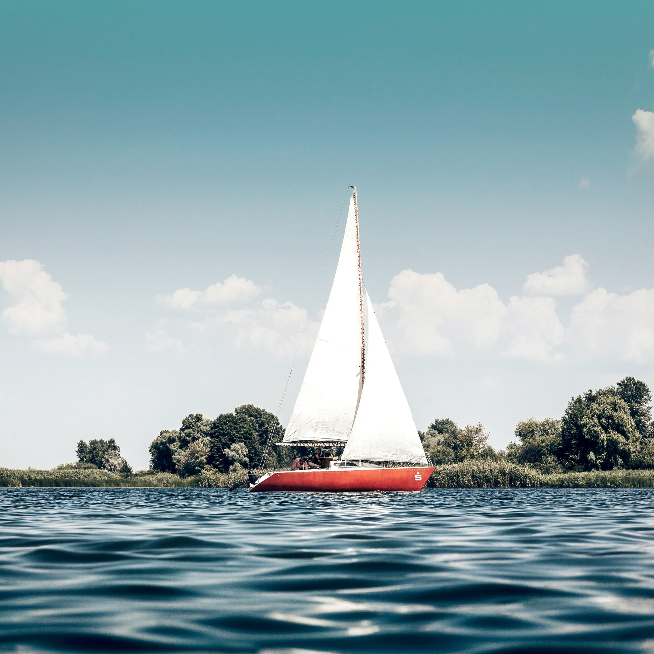 hochzwei_privatebanking_teaser_05.jpg Rotes Segelboot auf dem Wasser