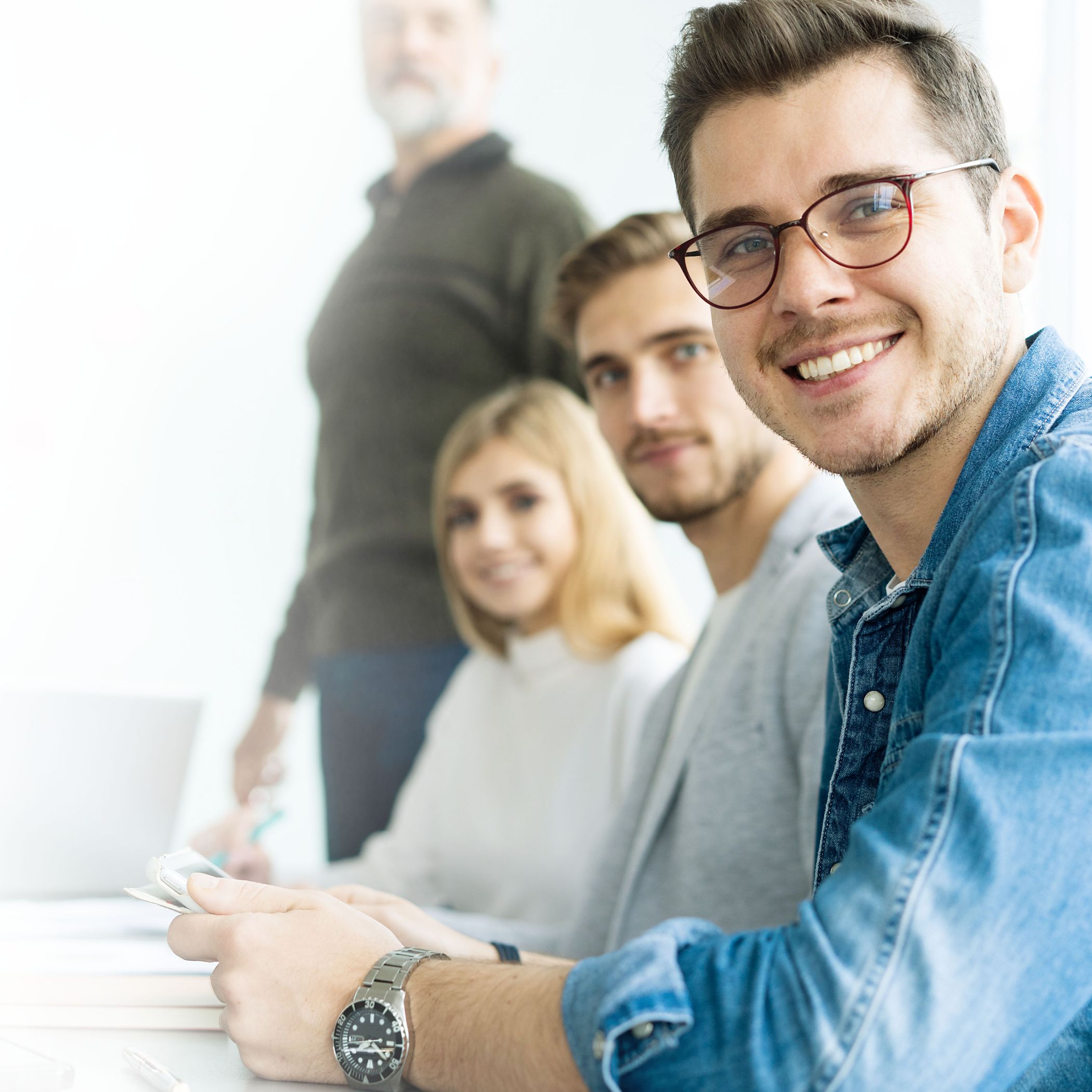 h2_swsh_startwerke_teaser_02.jpg Vier Menschen sitzen bzw. stehen in einer Reihe und schauen lächeln in die Kamera.