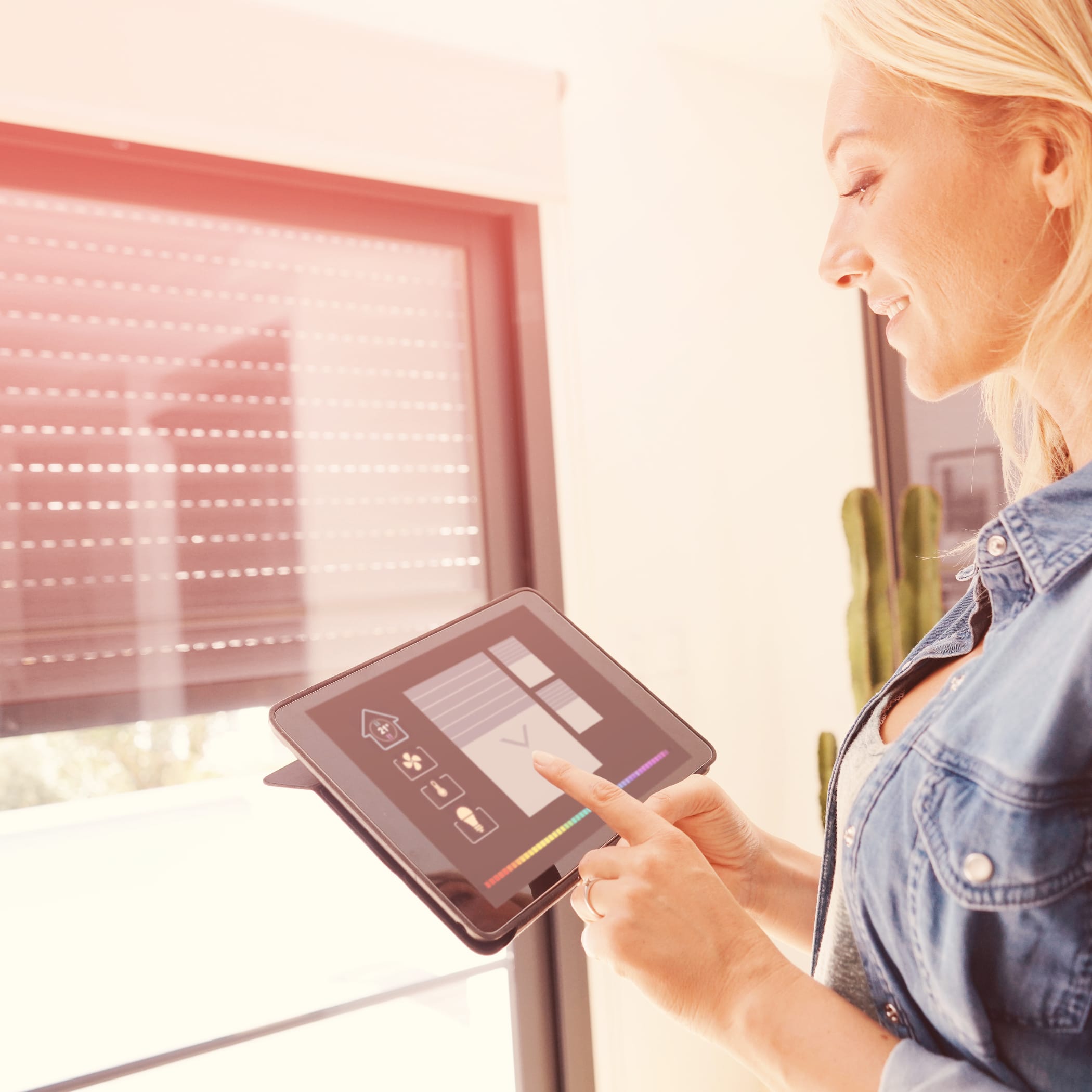 hochzwei_stn_teaser_02.jpg Frau hält Ipad in der Hand und steuert damit ihre Jalousien