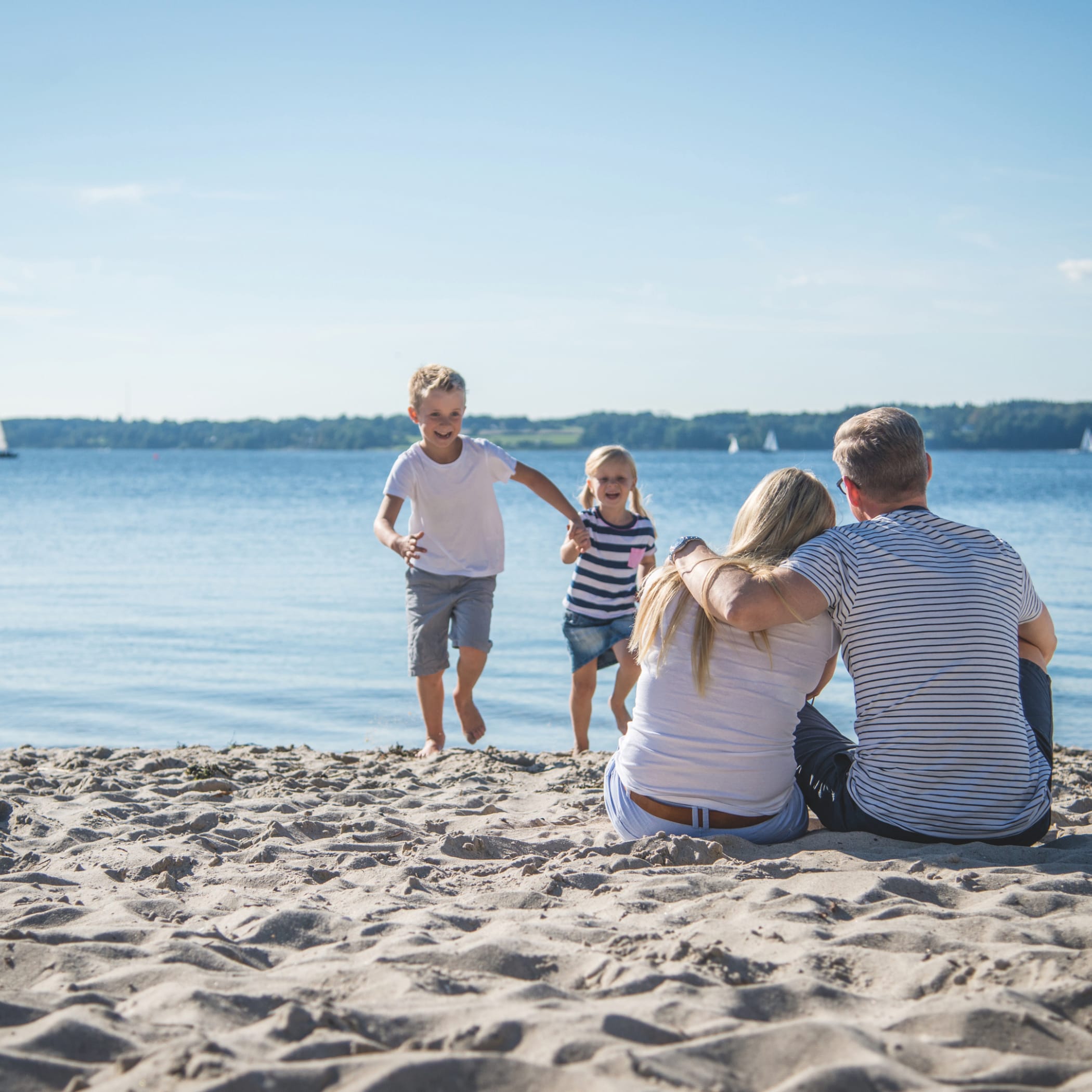 hochzwei_srgl_teaser_02.jpg Familie sitzt bei gutem Wetter am Strand