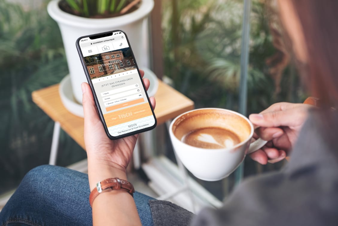 hochzwei_host_teaser_gross_03.jpg Frau trinkt einen Kaffee auf dem Balkon