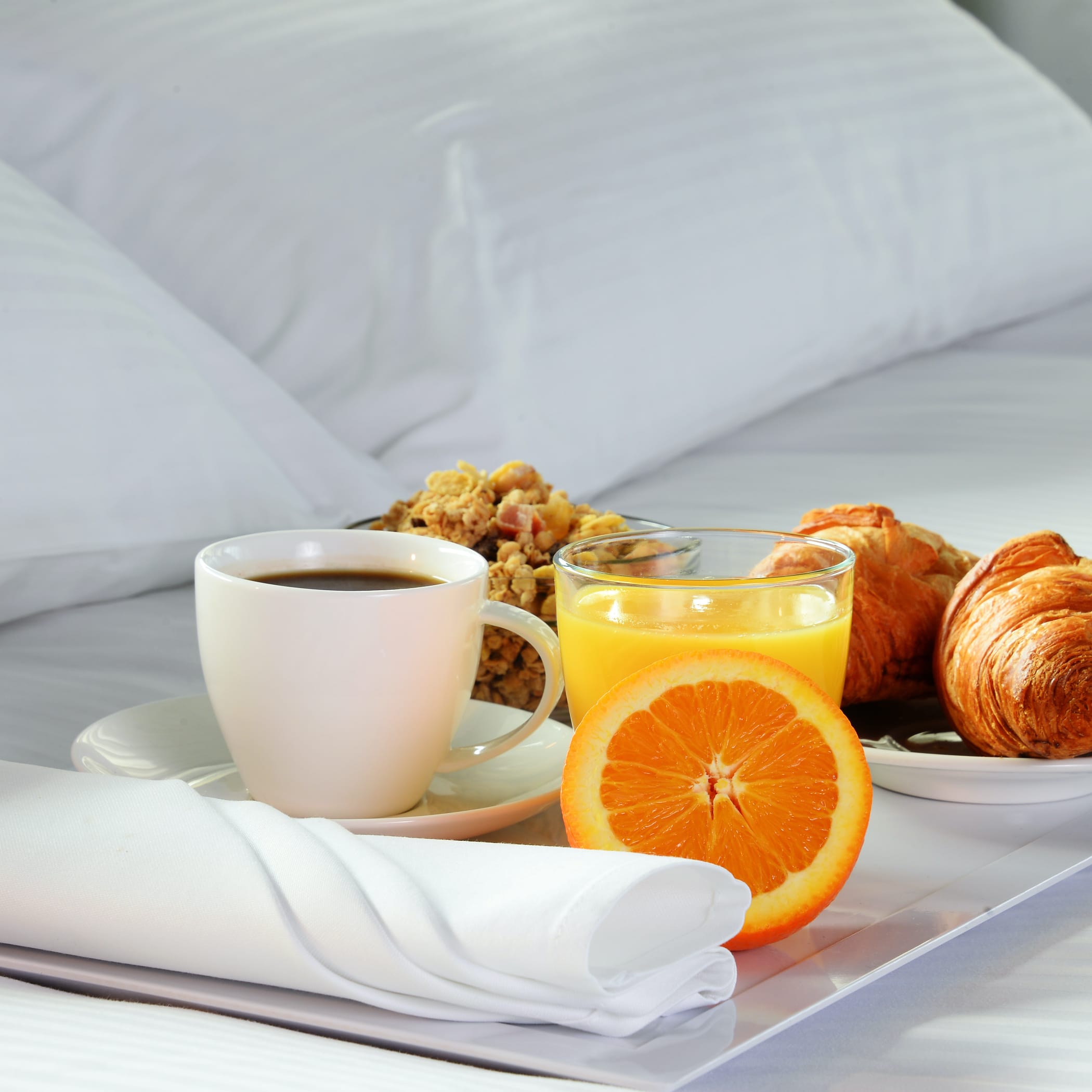 hochzwei_host_teaser_02.jpg Tablett mit Croissant, Kaffee und einer Orange