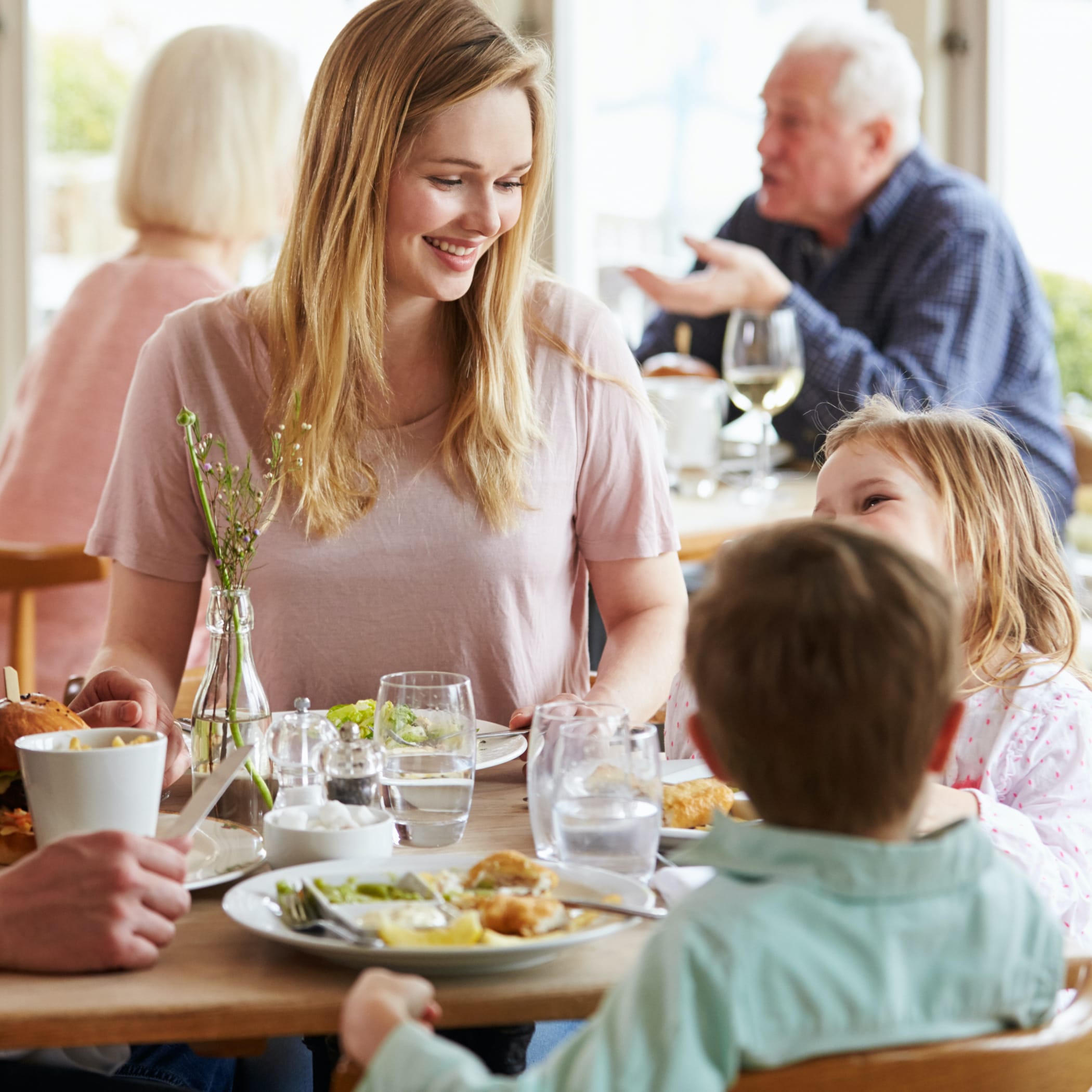 hochzwei_host_teaser_04.jpg Mutter sitzt am Frühstückstisch mit zwei Kindern
