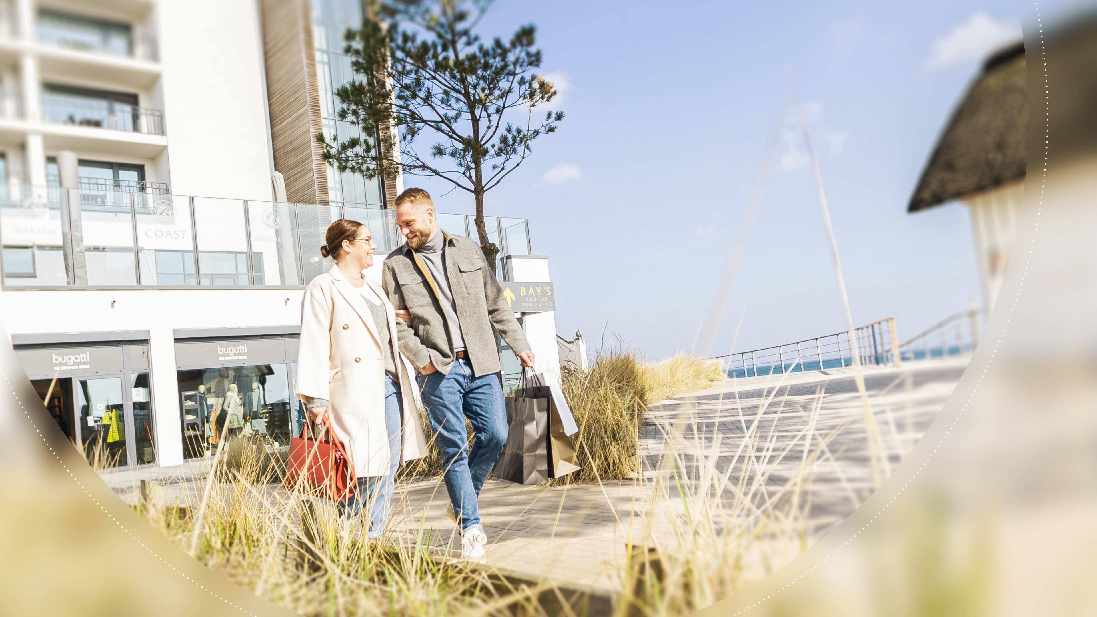 Pärchen geht shoppen an einer Strand Promenade