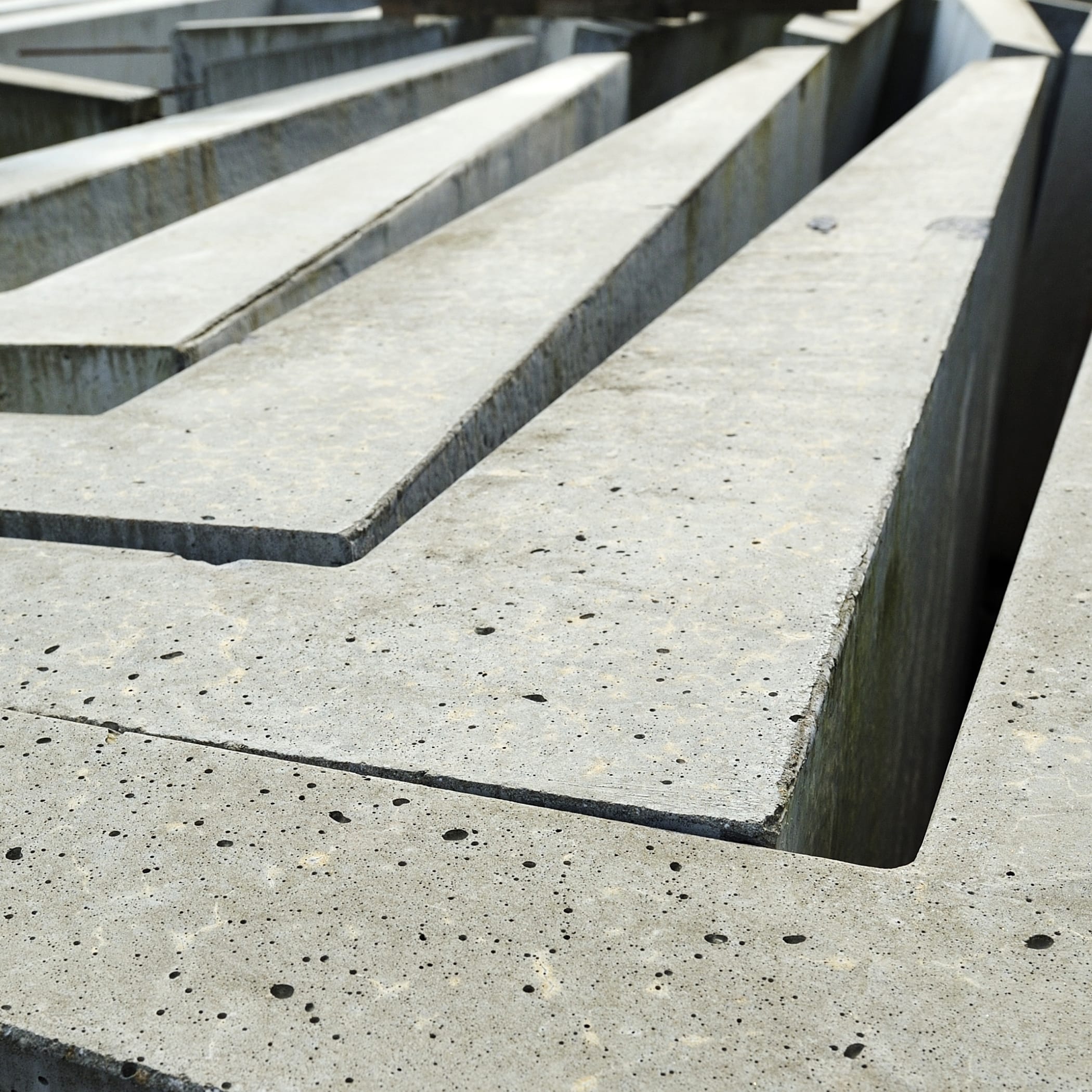 hochzwei_tiefbau_teaser_03.jpg Graue Betonleisten liegen in der Sonne