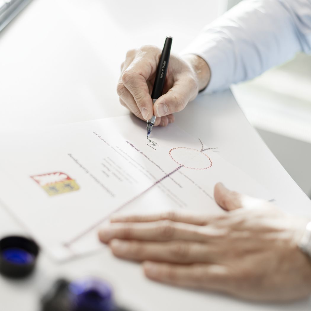 hochzwei_ttpRelaunch_teaser_7.jpg Eine Person unterschreibt ein Dokument