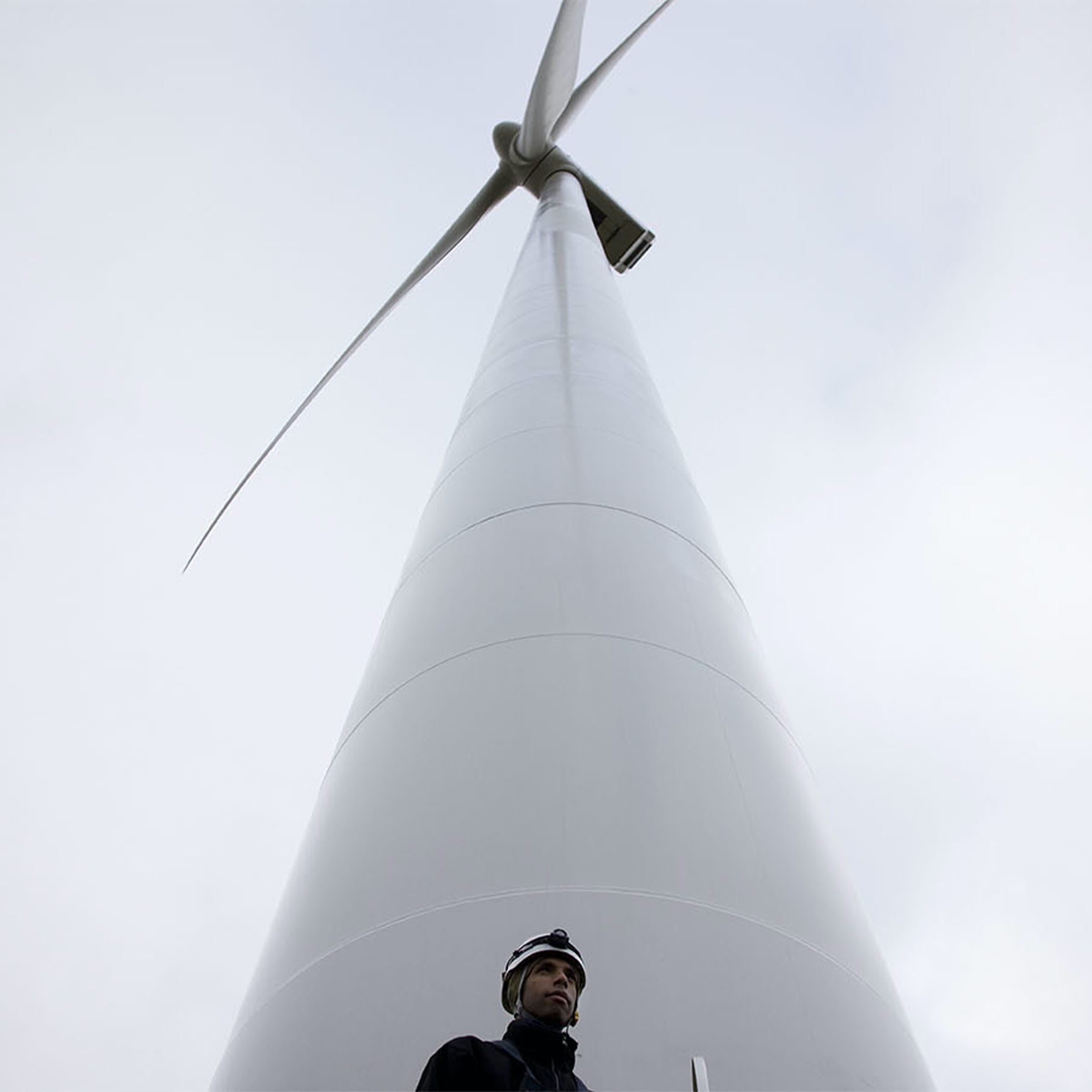 hochzwei_vest_teaser_03.jpg Mann steht an weißem Windrad