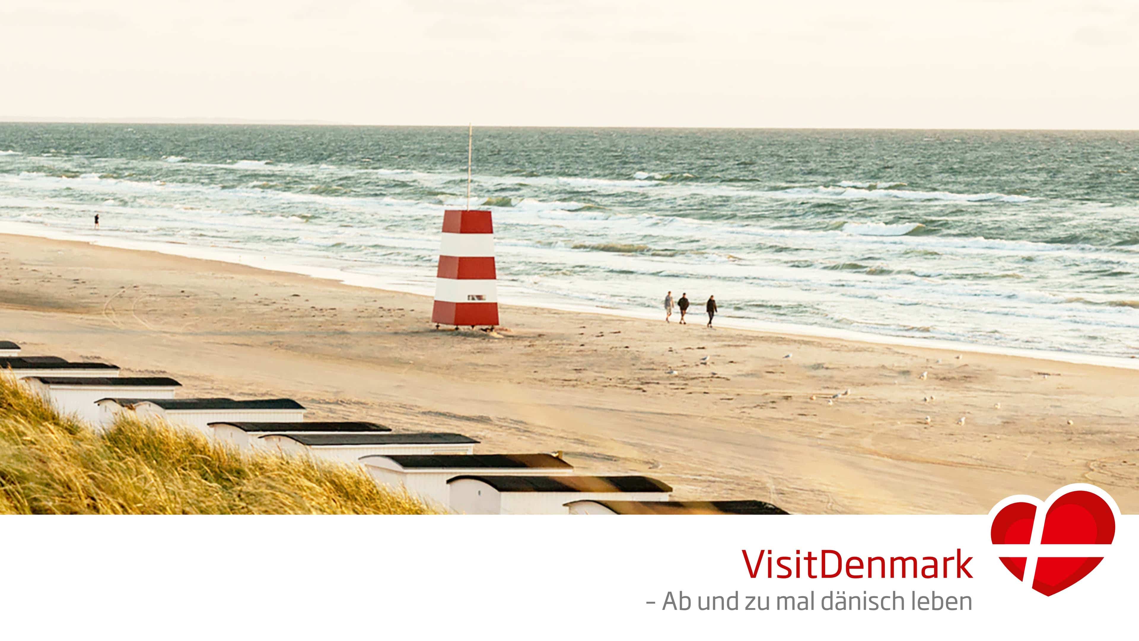 Drei Personen gehen am Strand spazieren
