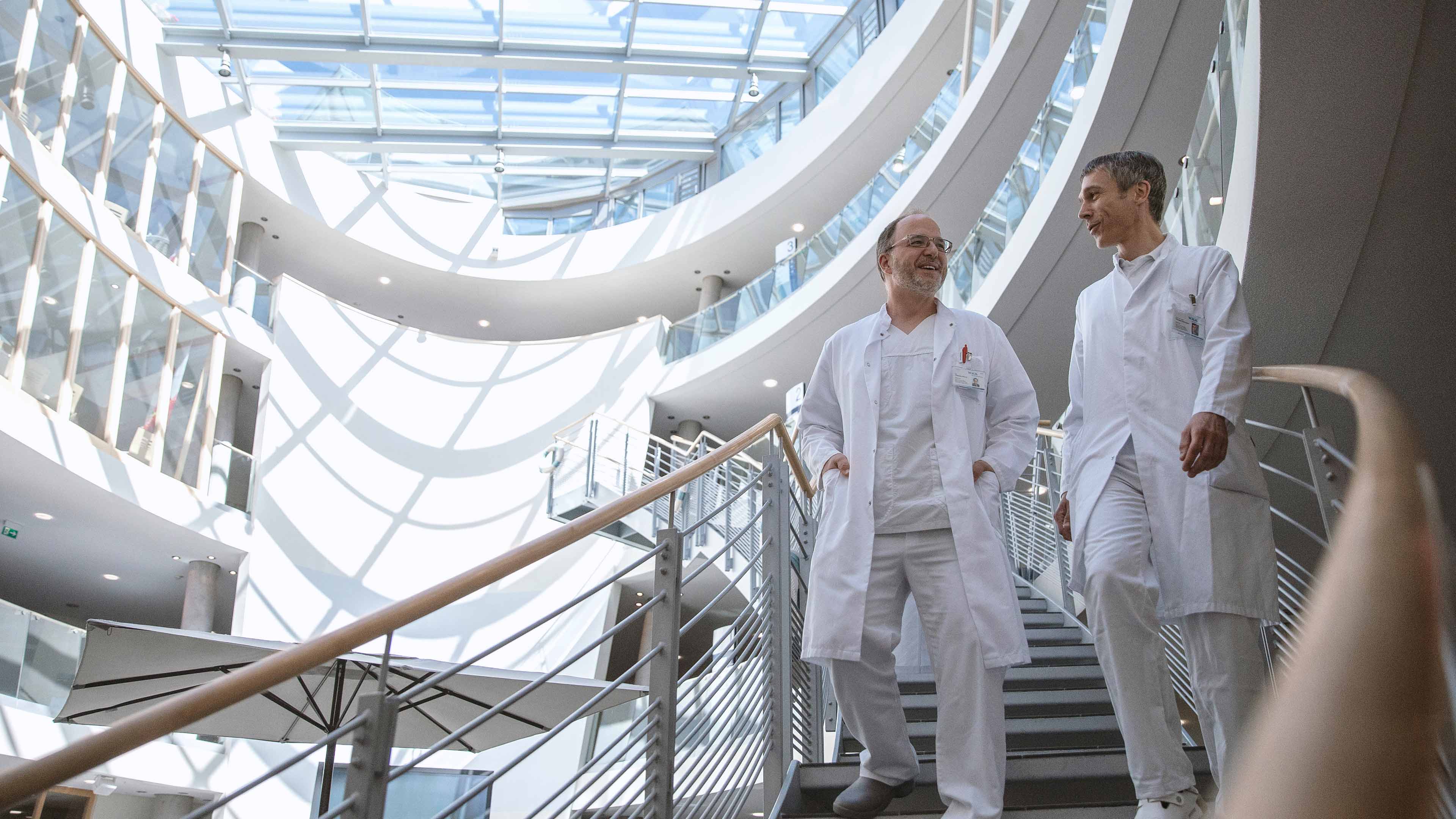 Zwei Ärzte gehen die Treppe runter