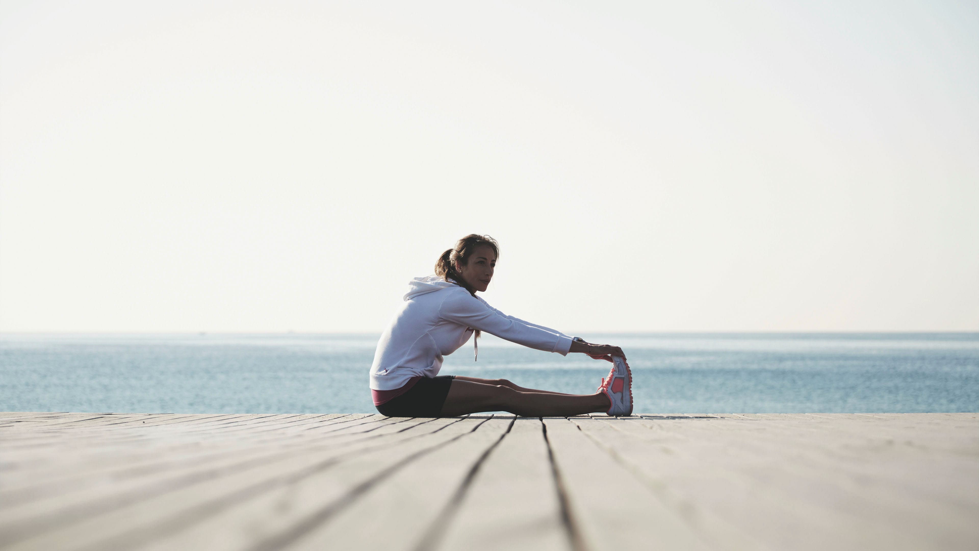 Frau dehnt sich auf einem Steg