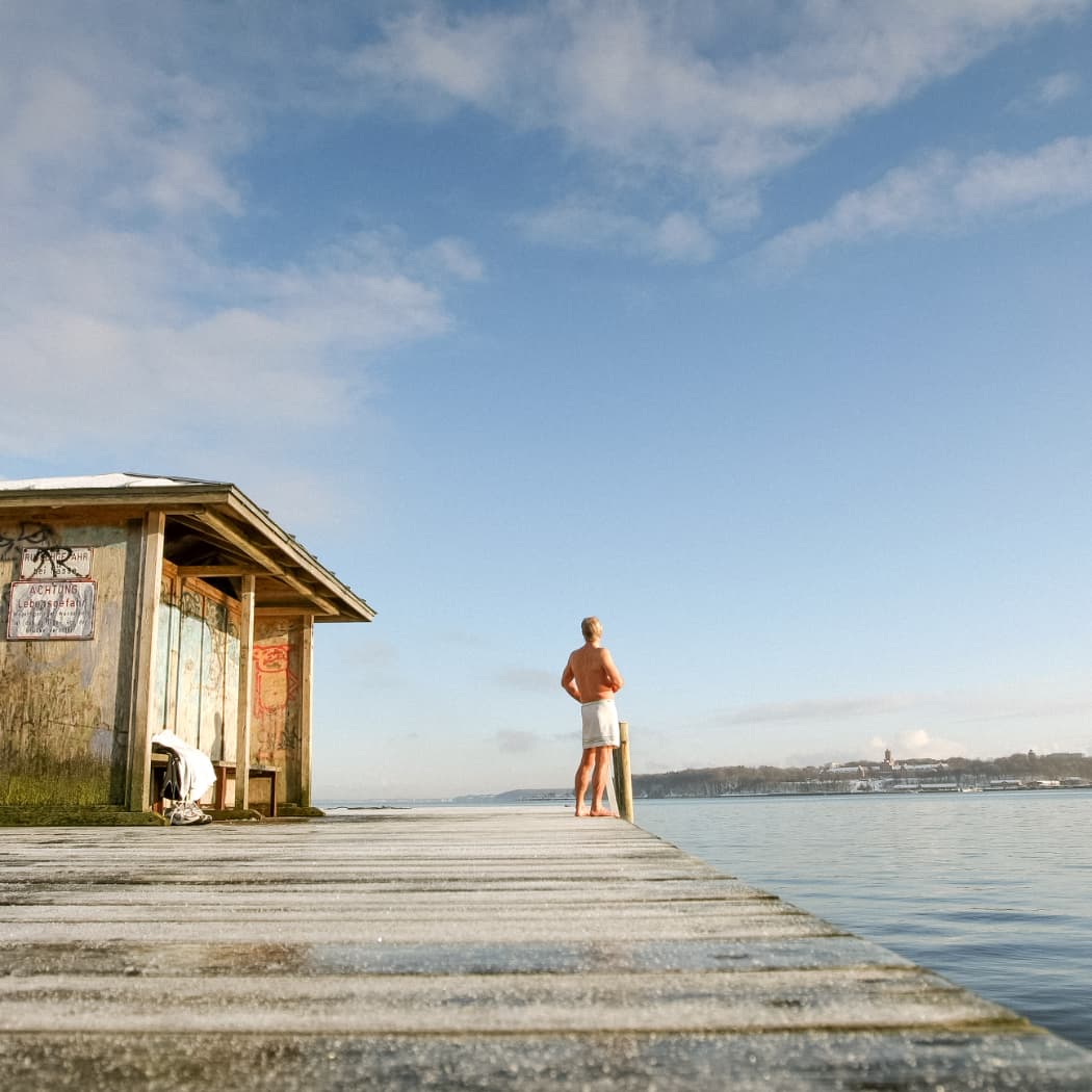 hochzwei_flensburg_teaser_03.jpg Mann auf Steg am Wasser