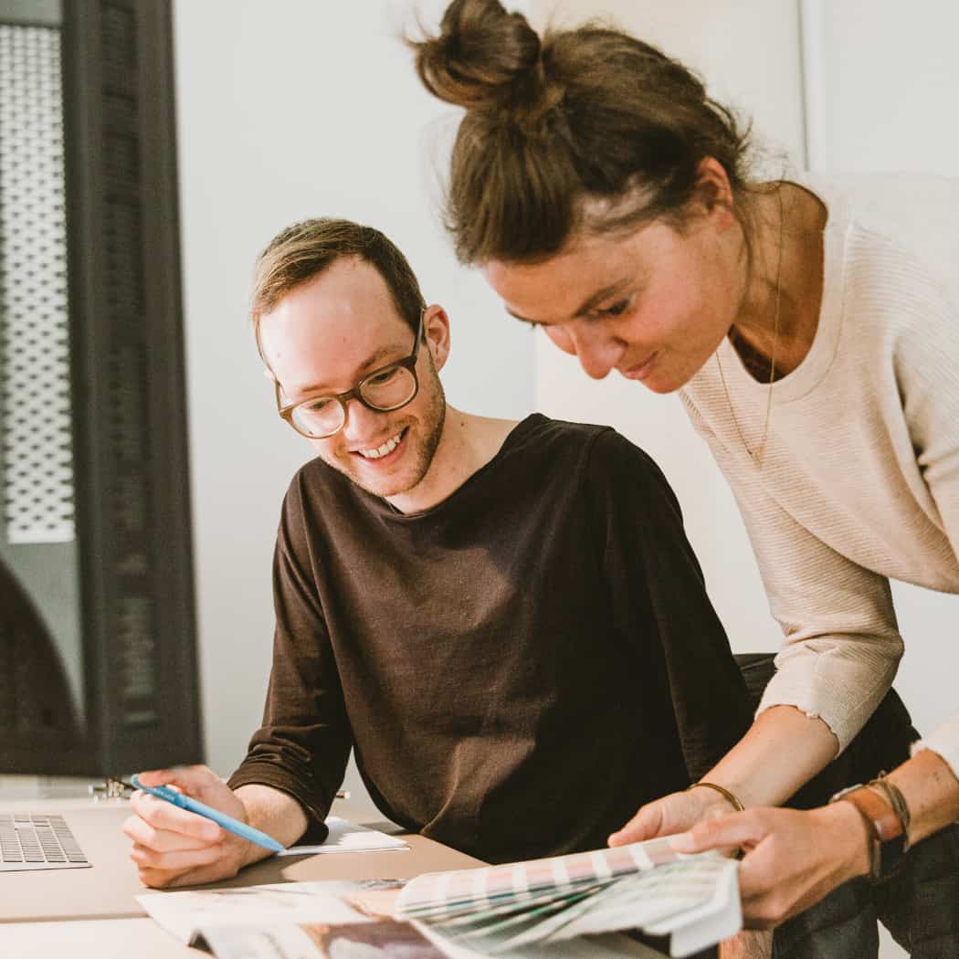 hochzwei_darumhochzwei_teaser_08.jpg Zwei Hochzwei Mitarbeiter schauen auf Farbpalette