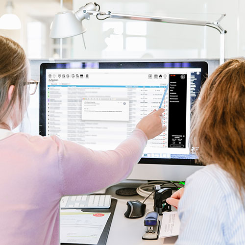 Hochzwei Mitarbeiterin zeigt auf Computer