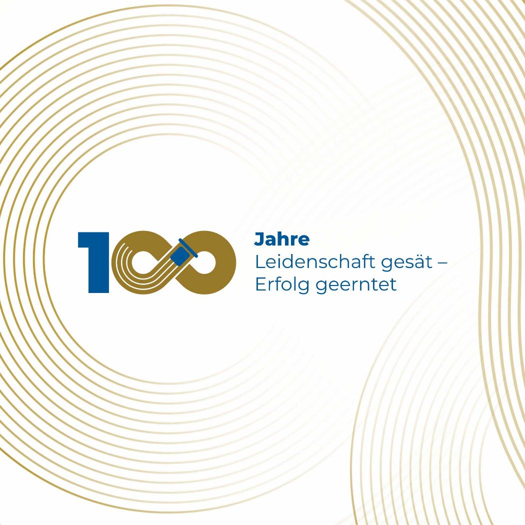 100 Jahre Wüstenberg - Leidenschaft gesät, Erfolg geerntet Logo in beige mit blau. Die beiden Nullen der 100 sind als kleiner Mähdräscher, der eine liegende 8 fährt entworfen.