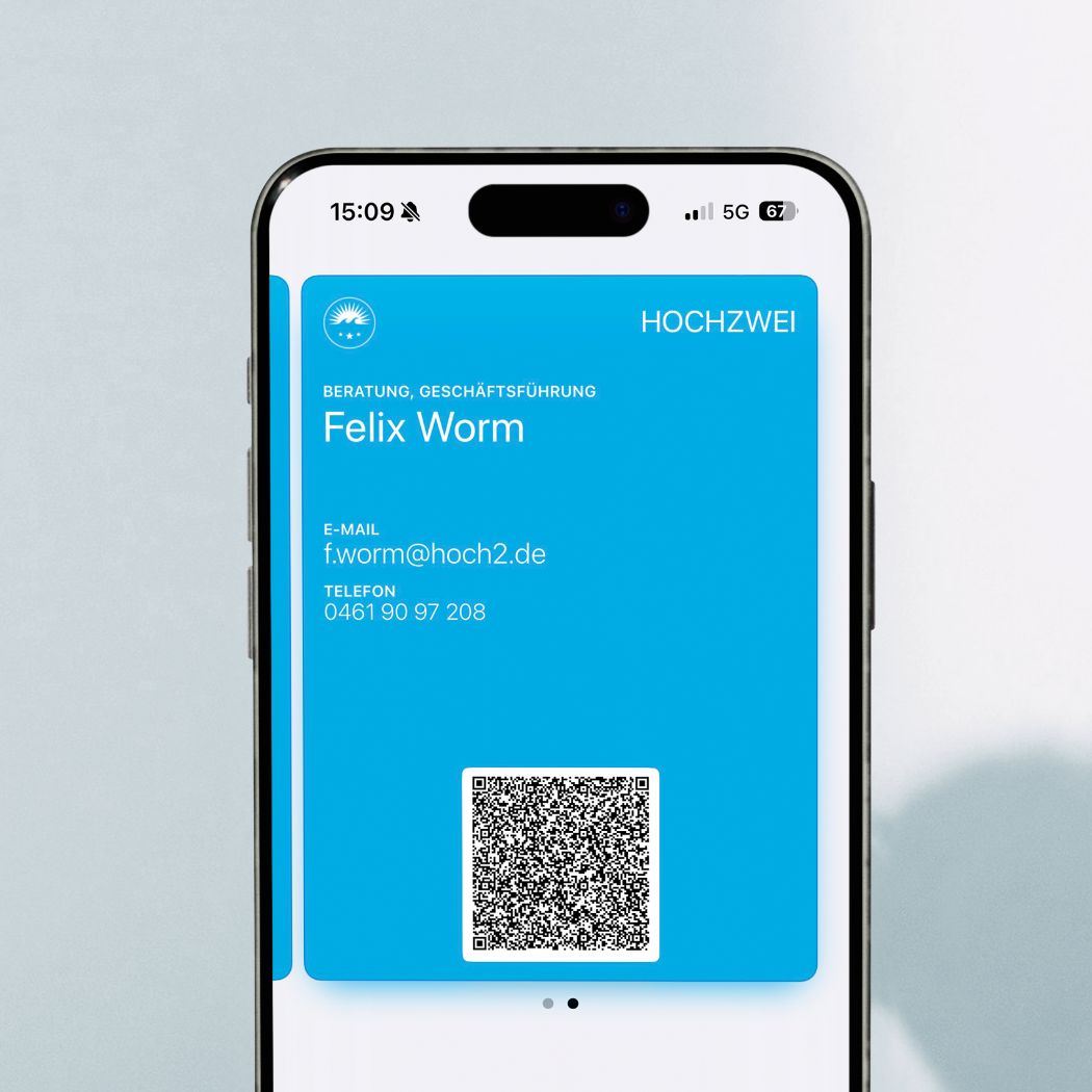 Smartphone mit einer digitalen Visitenkarte mit Name, E-Mail-Adresse, Telefonnummer und einem QR-Code