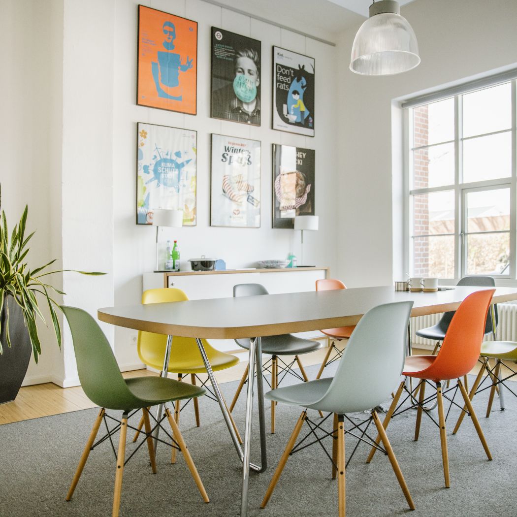 Konferenzraum mit langem Tisch und bunten Stühlen