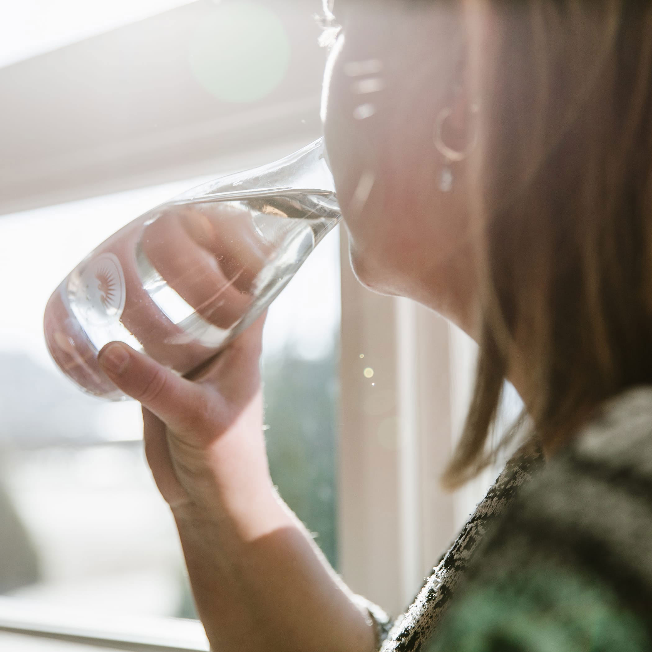 Eine Frau trinkt Wasser aus einem Glas