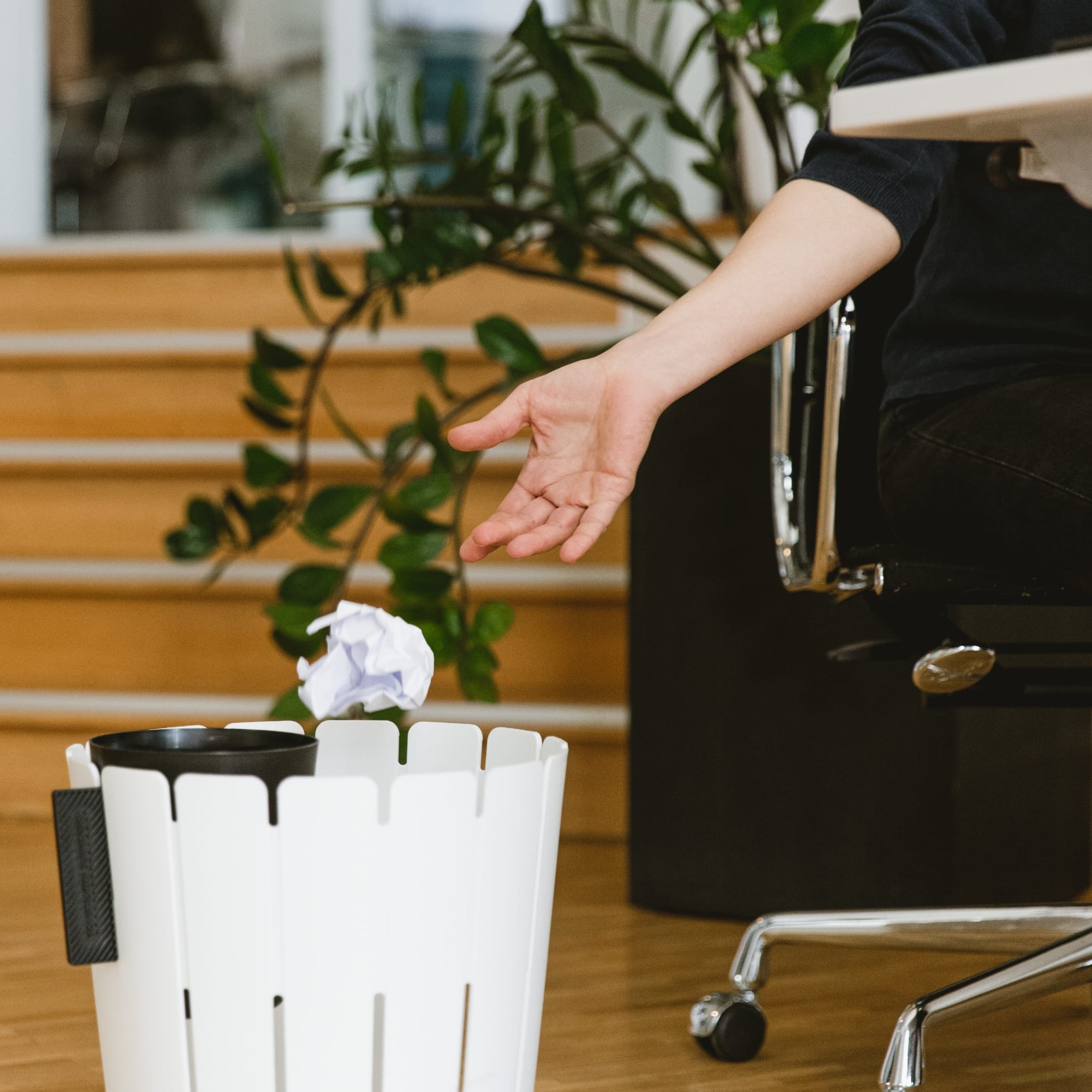 Person wirft Papier in den Müll