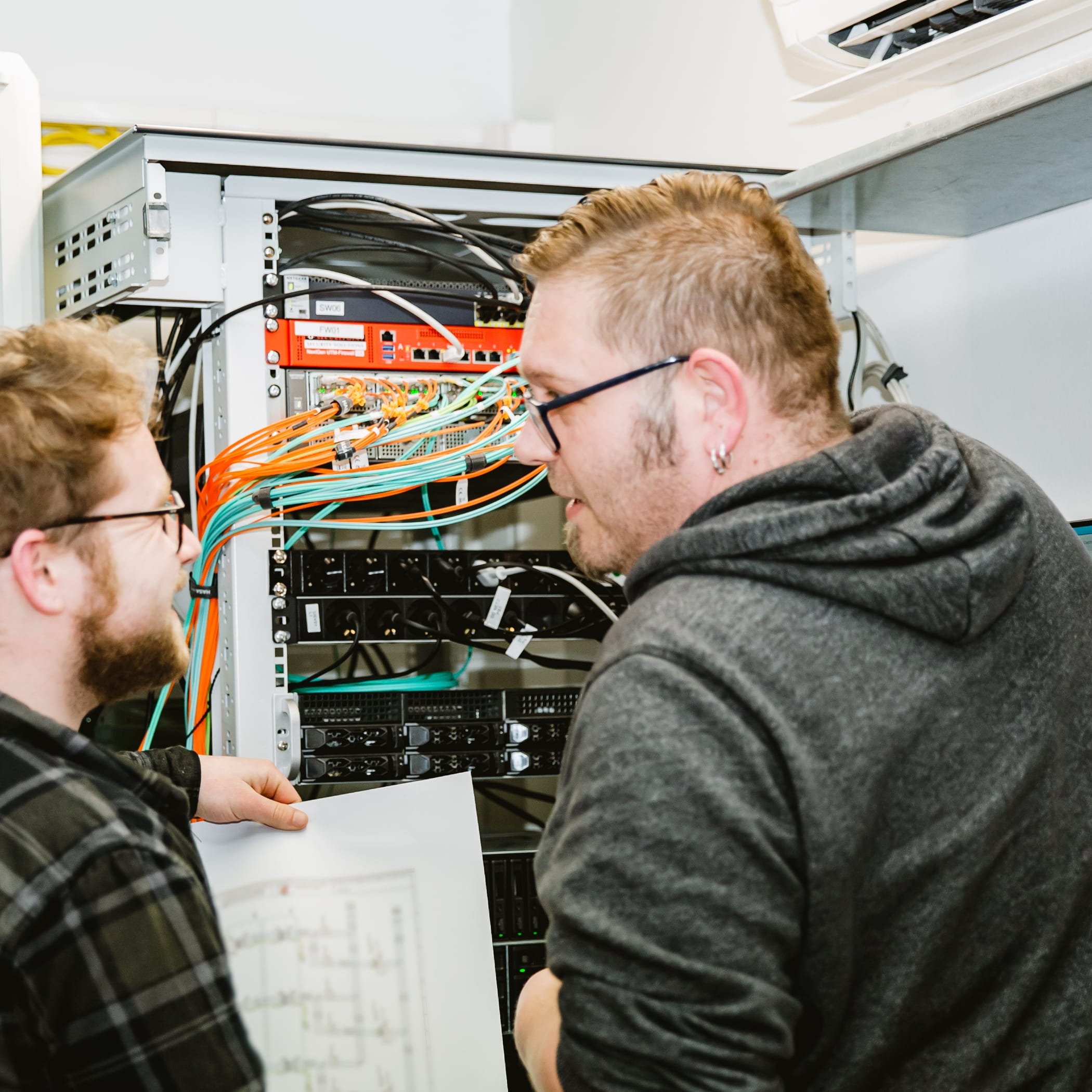 Zwei Hochzwei Mitarbeiter stehen vor einer Maschine