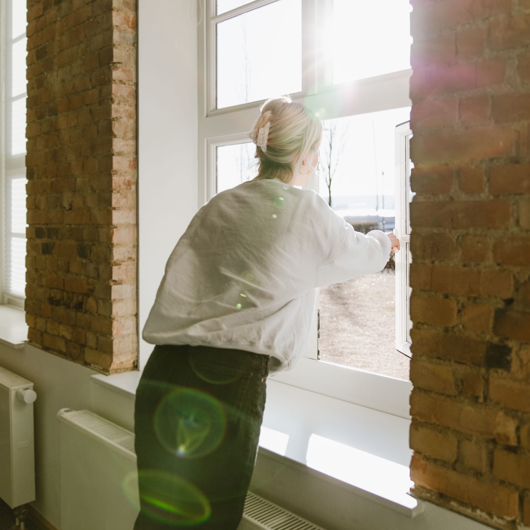 Frau öffnet Fenster