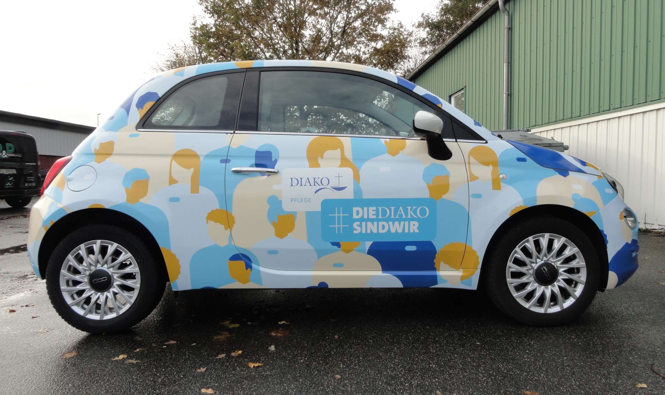 Ein Fiat 500 im Design der DIAKO auf einem Parkplatz.