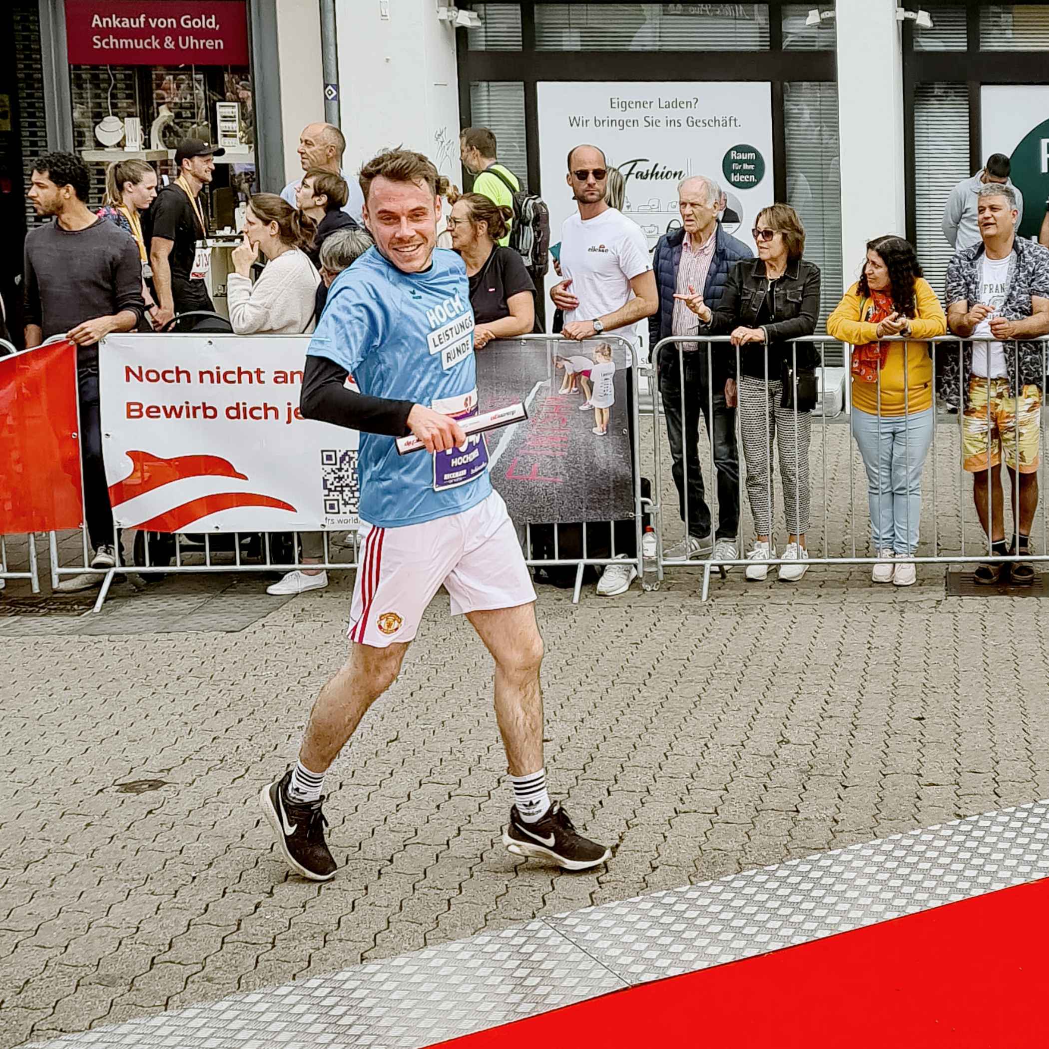 Unser Kollege Jonas trägt den Stab auf der Zielgeraden.