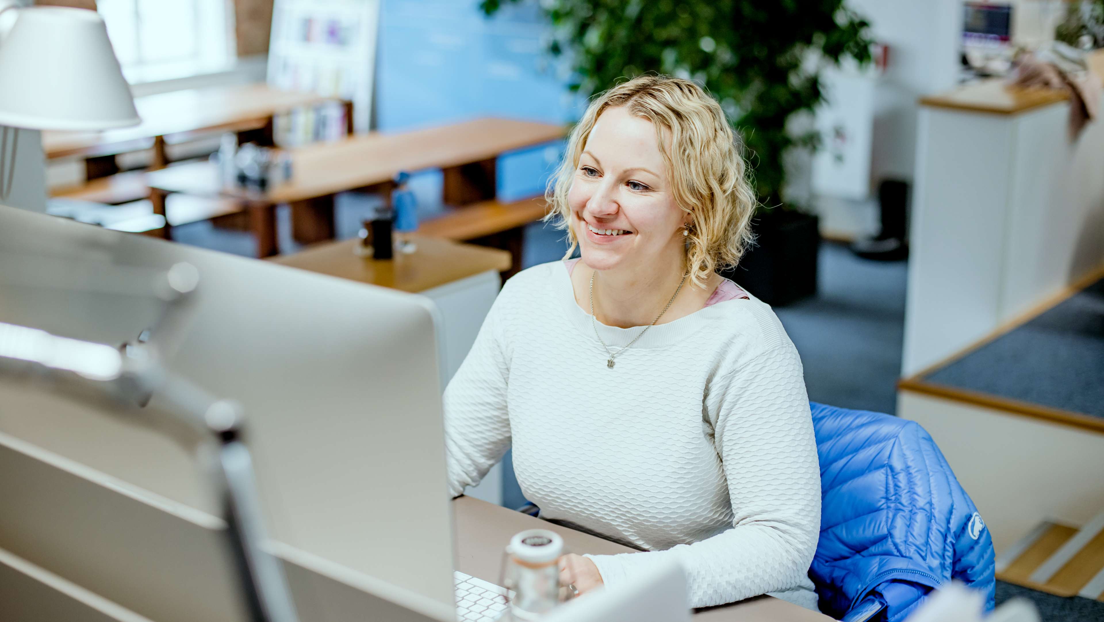 HOCHZWEI Mitarbeiterin Rebecca am Schreibtisch sitzend
