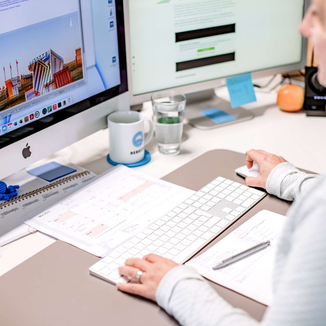 HOCHZWEI Mitarbeiterin Rebecca von hinten am Computer sitzend