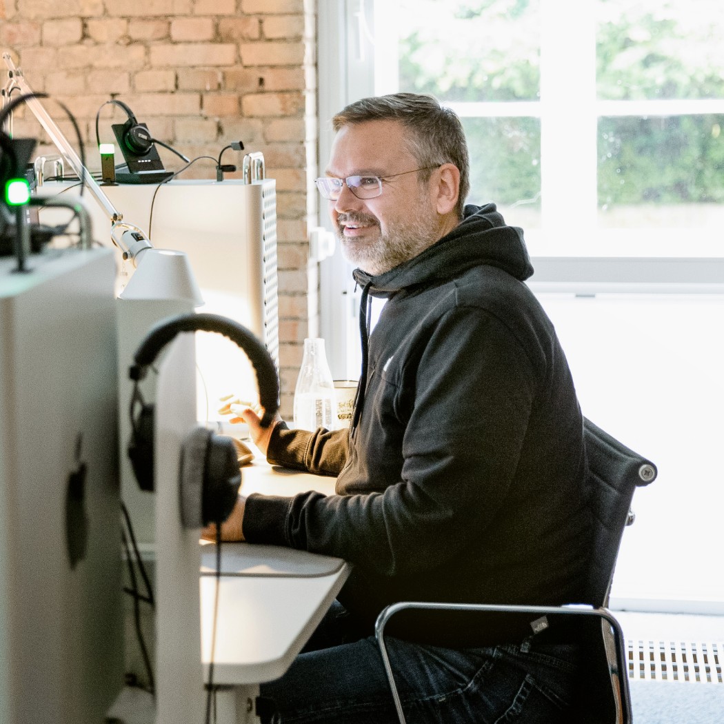 h2_einblicke_remote-onsite_teaser_05.jpg Der Senior-Grafiker und Prokurist Olaf bei der Arbeit.