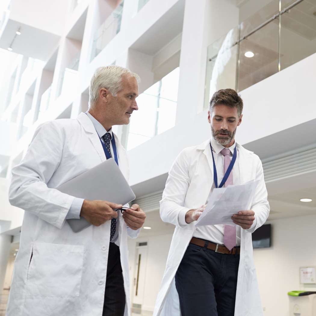 h2_einblicke_gesundheitsmarkt_teaser_02.jpg Zwei Ärzte besprechen sich im Krankenhausflur.