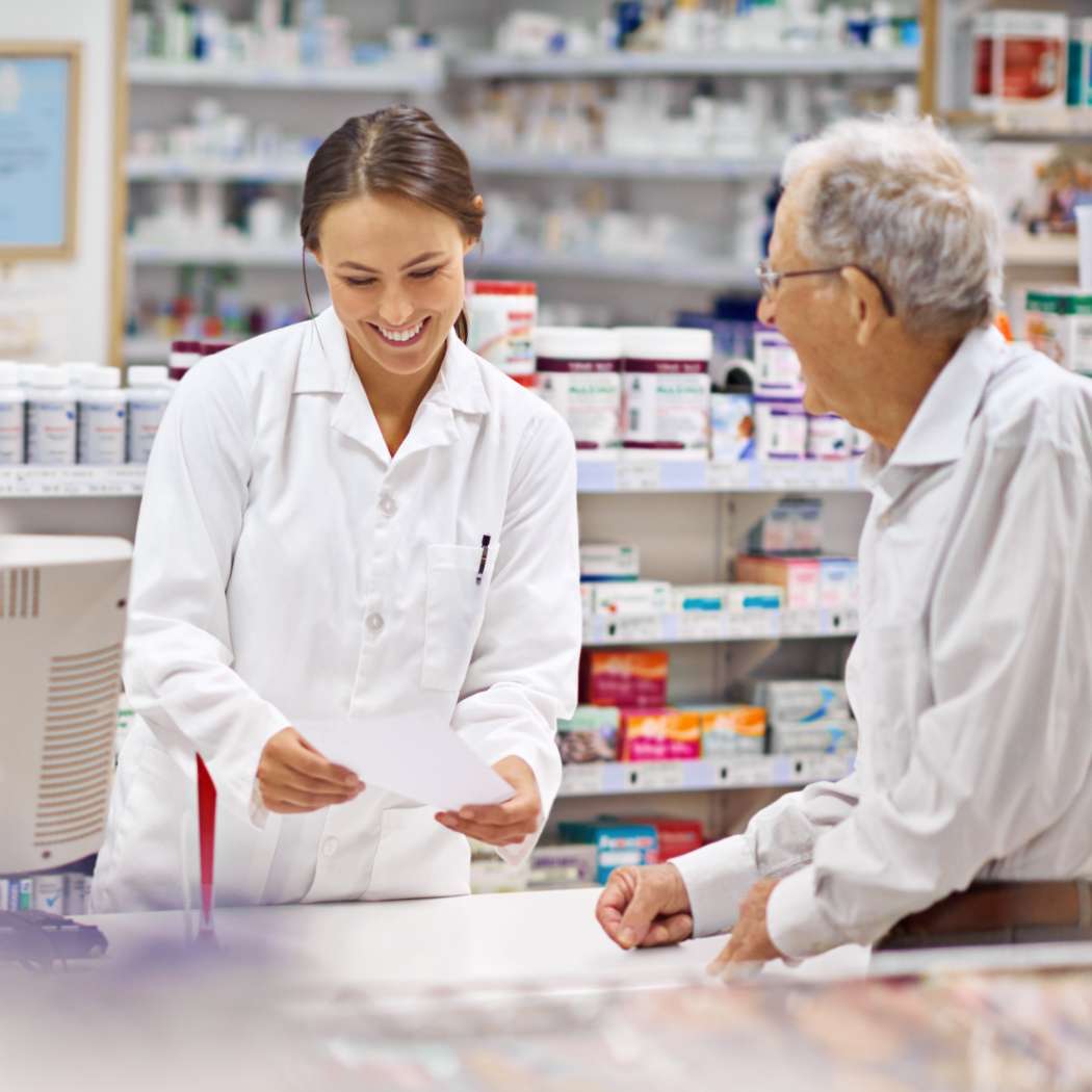 h2_einblicke_gesundheitsmarkt_teaser_03.jpg Eine Angestellte einer Apotheke hilft einem älteren Mann mit seinem Rezept.