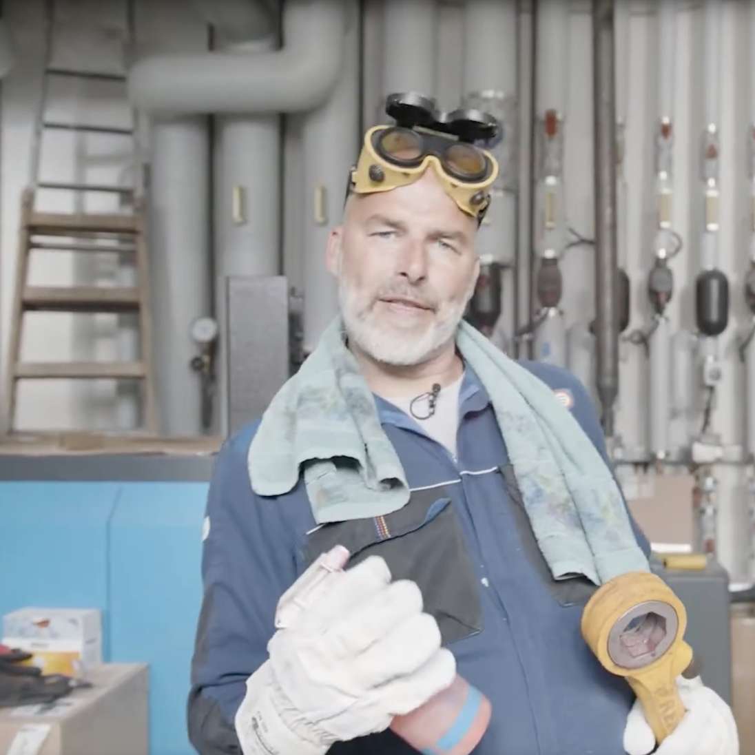 York trägt Arbeitshandschuhe sowie Schutzkleidung und eine Schweißerbrille