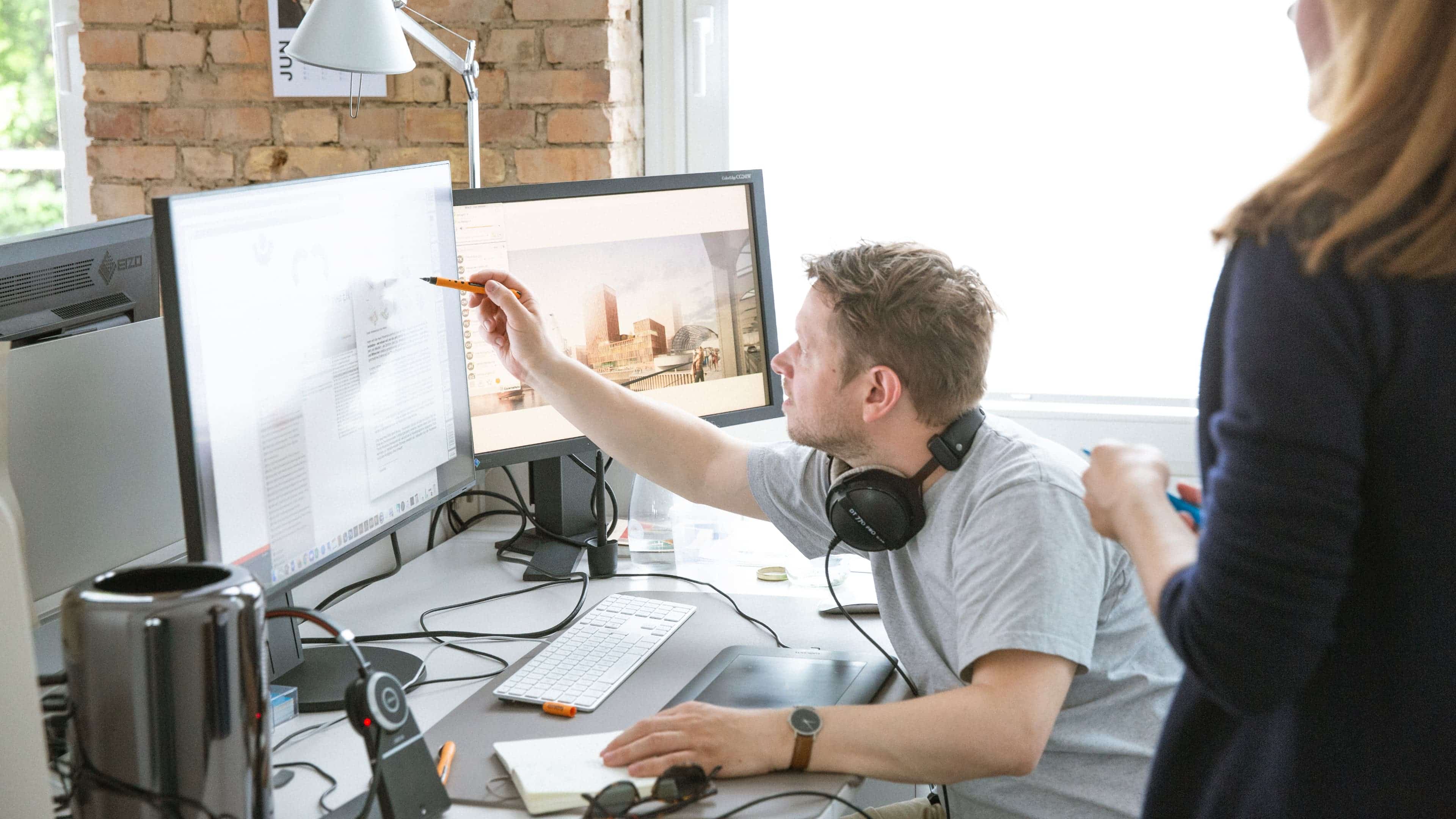 Mitarbeiter zeigt auf Computerbildschirm