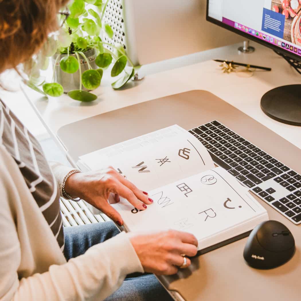 hochzwei_wir_teaser_02.jpg Mitarbeiterin blättert in Katalog