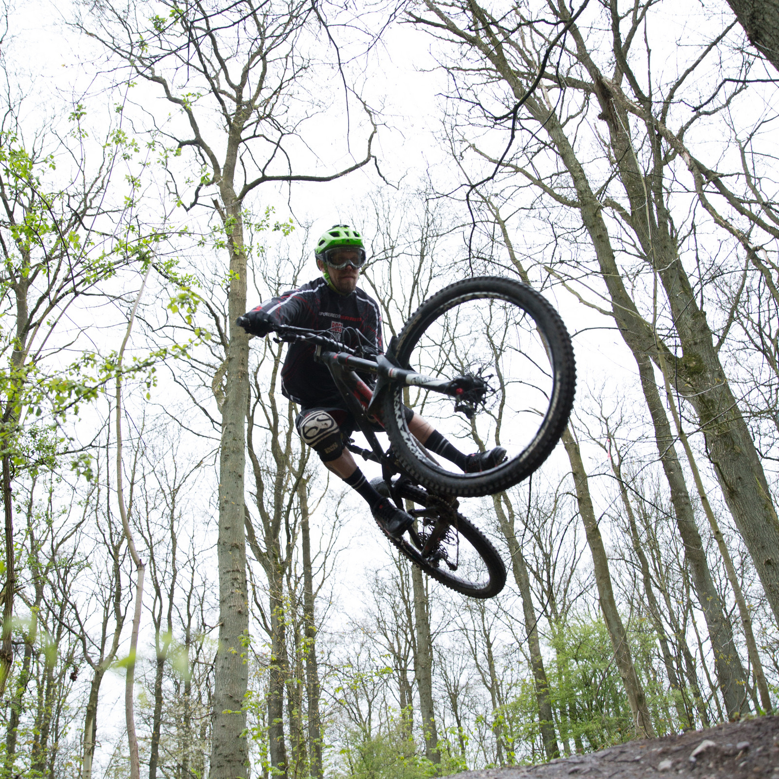 hochzwei_deso_teaser_03.jpg Mountainbikefahrer mit grünem Helm mitten im Sprung