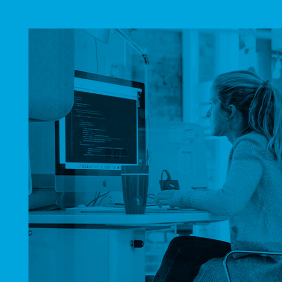 Was ist bei der Programmierung einer neuen Website zu beachten? Mitarbeiterin an ihrem Arbeitsplatz