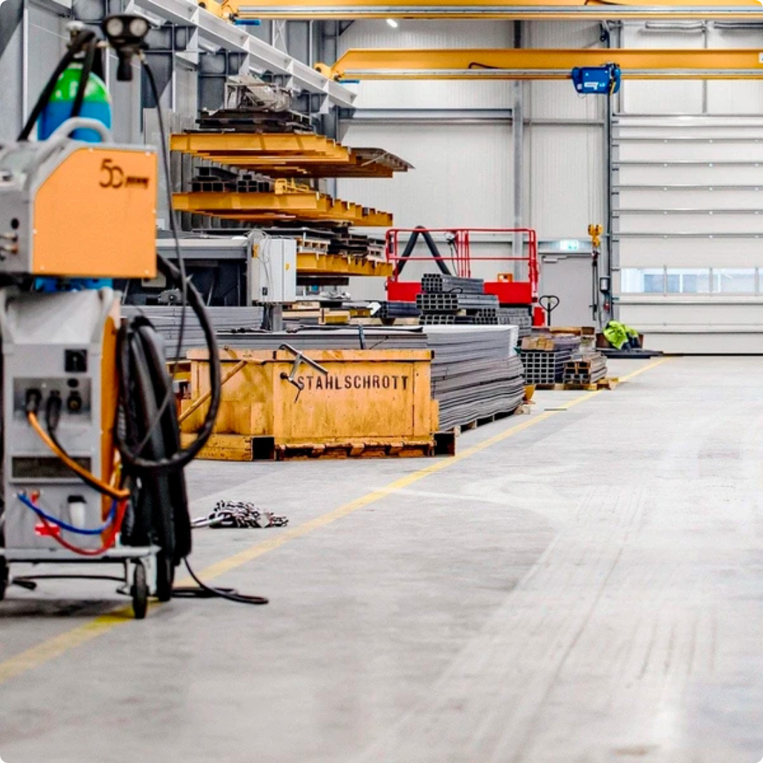 h2_futura_teaser_08.jpg Eine Lagerhalle mit einem Container auf dem Stahlschrott steht.