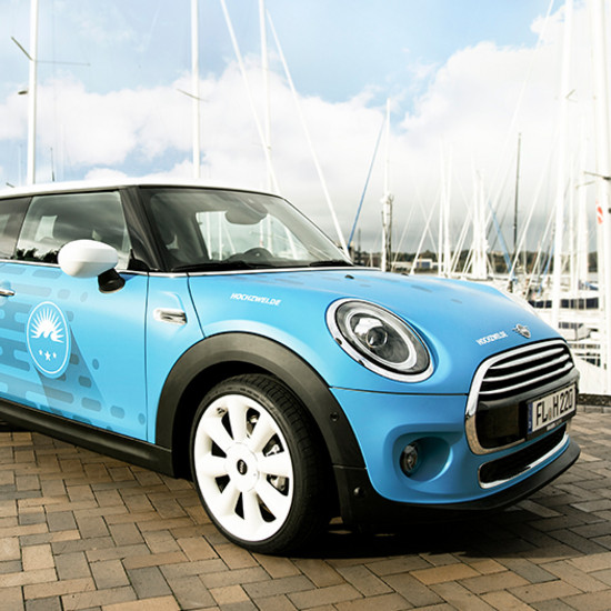 Kreativität auf Rädern Blauer Mini Cooper am Hafen