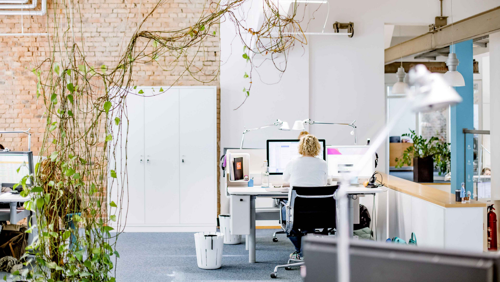 HOCHZWEI Büro mit Mitarbeiterin Rebecca am Schreibtisch sitzend