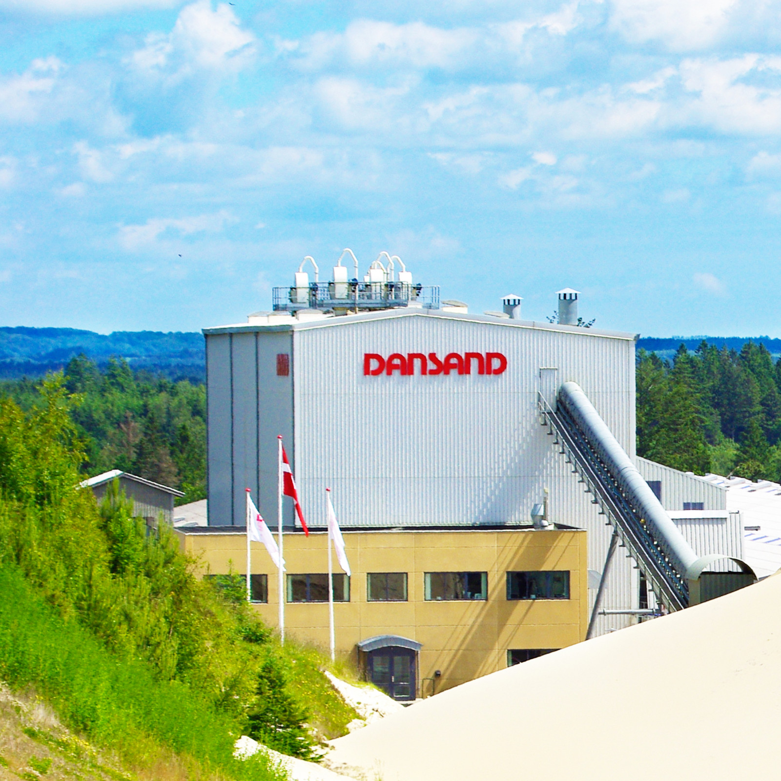 hochzwei_dansand_teaser_01.jpg Blick auf DANSAND-Gebäude im Kieswerk bei blauem Himmel