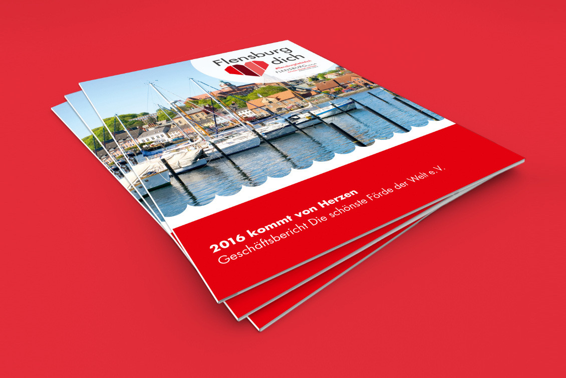 Stapel dreier Geschäftsberichte von Flensburg liebt dich vor rotem Hintergrund