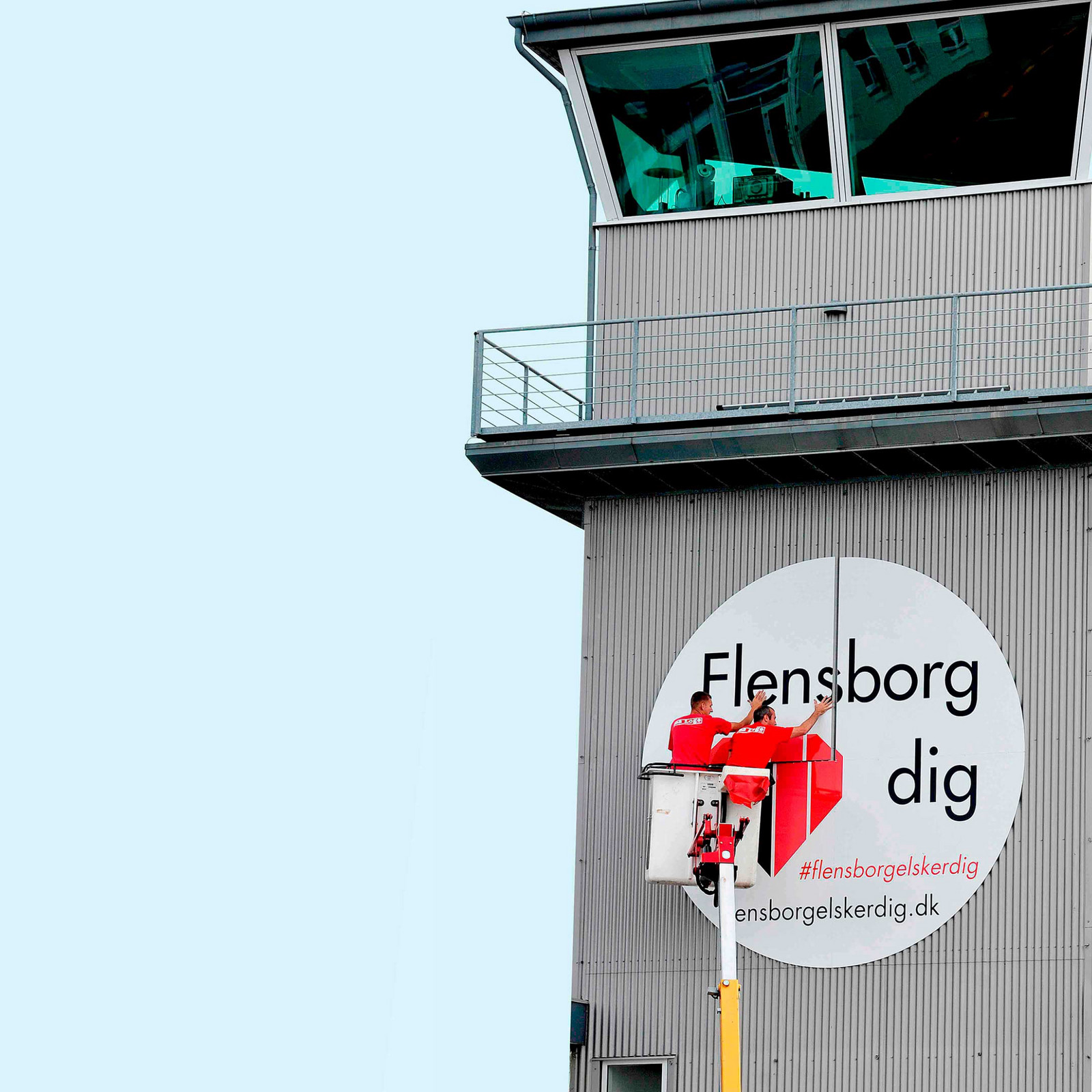 hochzwei_lufthavn_teaser_01.jpg Zwei Männer bringen großen Aufkleber