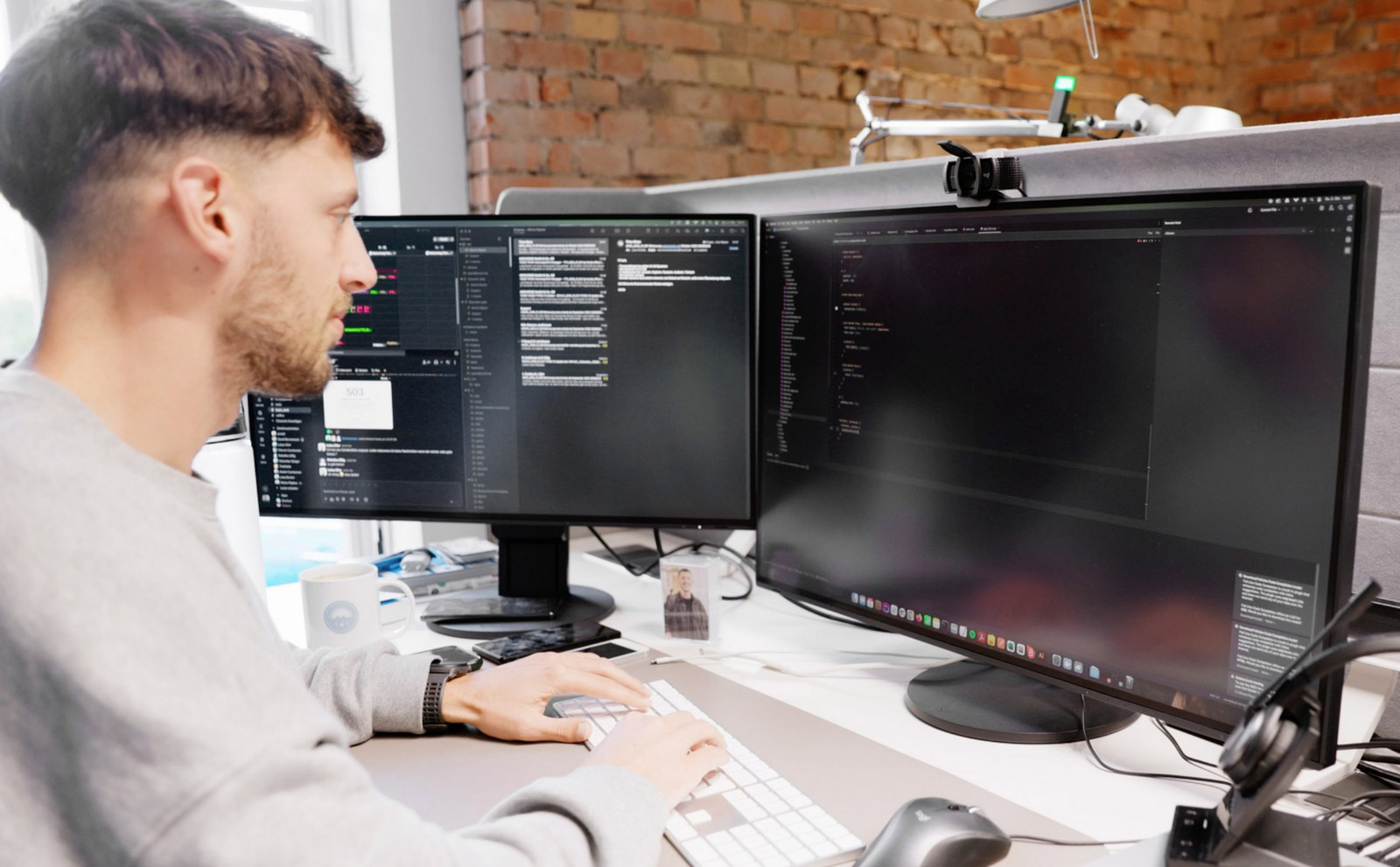 Ein Mitarbeiter von Hochzwei an seinem Arbeitsplatz mit zwei Bildschirmen