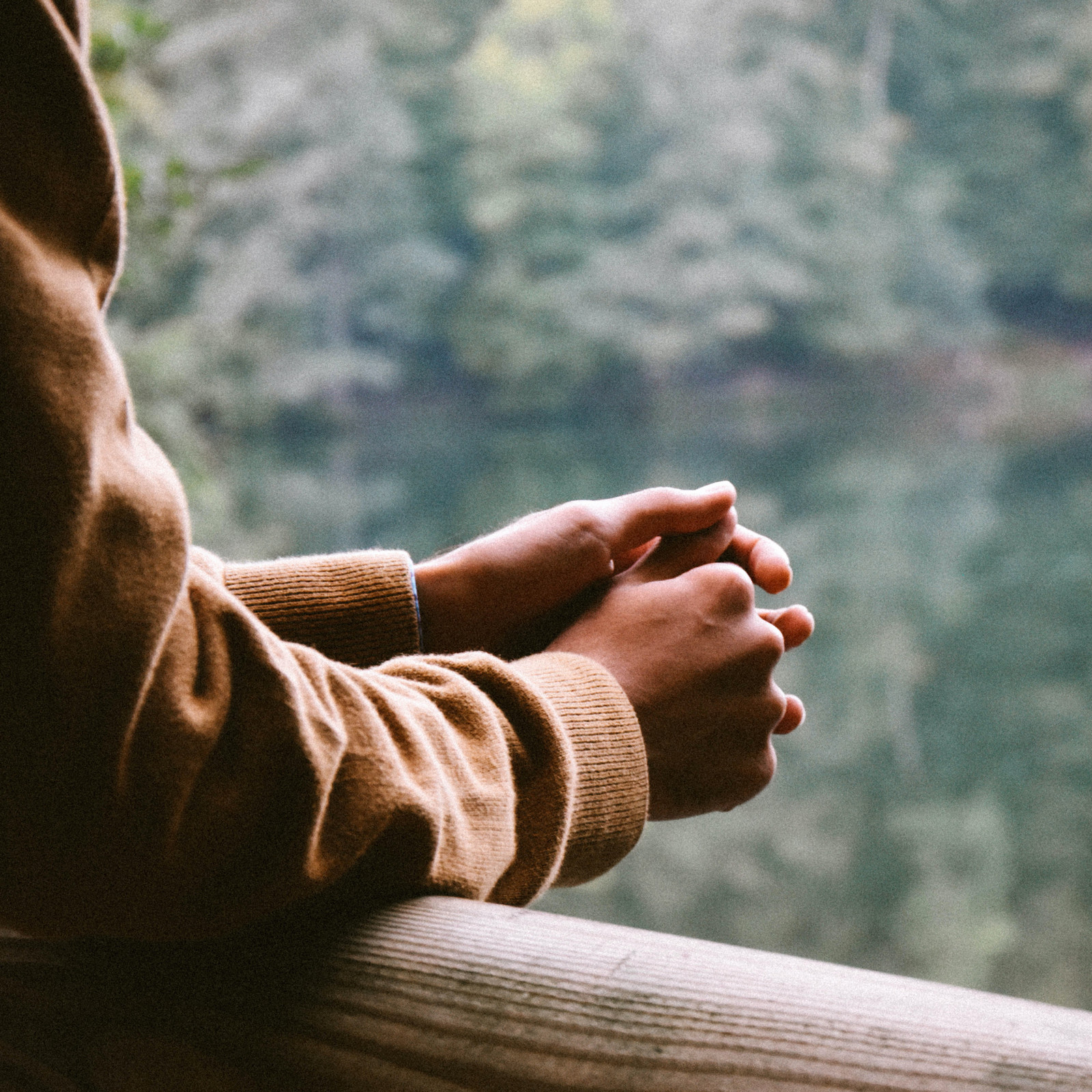 hochzwei_hos_teaser_09.jpg Eine Person lehnt sich auf ein Holzgeländer