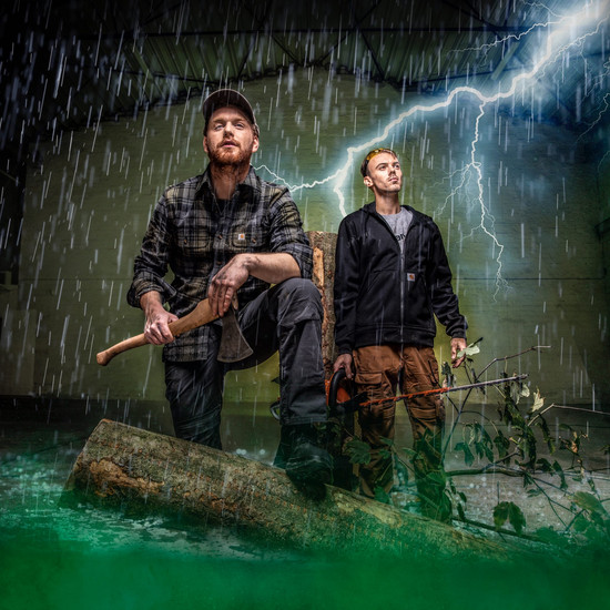 Zwei Georg C Mitarbeiter posieren bei Gewitter und Regen vor der Kamera