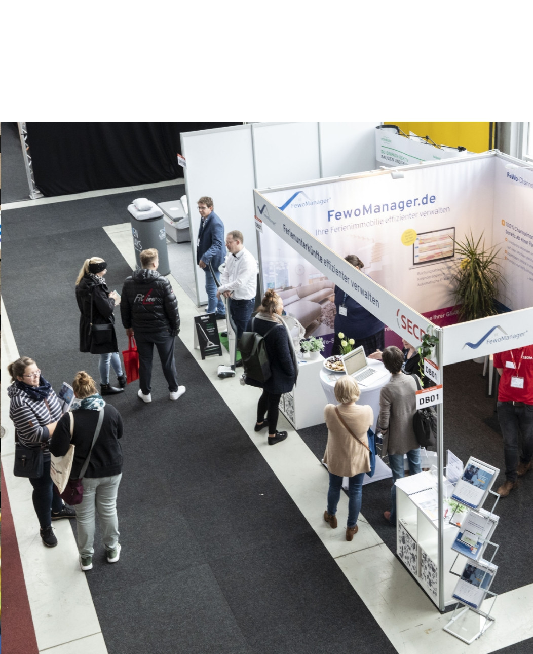 h2_domizil_teaser_06.jpg Zu sehen sind Besucher der Domizil Husum vor einem Messestand.