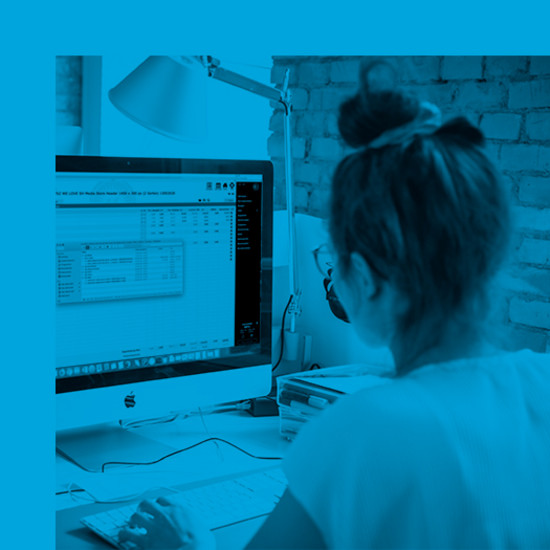 Wie wird eine Website mit Texten und Bildern gefüllt? Mitarbeiterin blickt auf Bildschirm mit Schulungsunterlagen