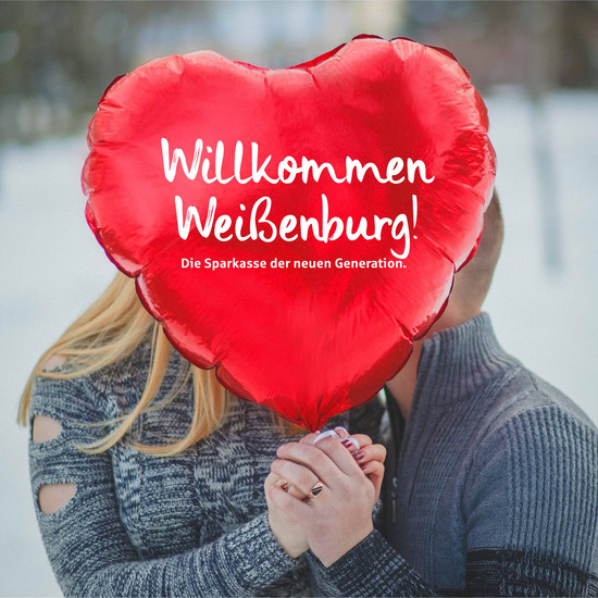 Pärchen hält roten Herzluftballon