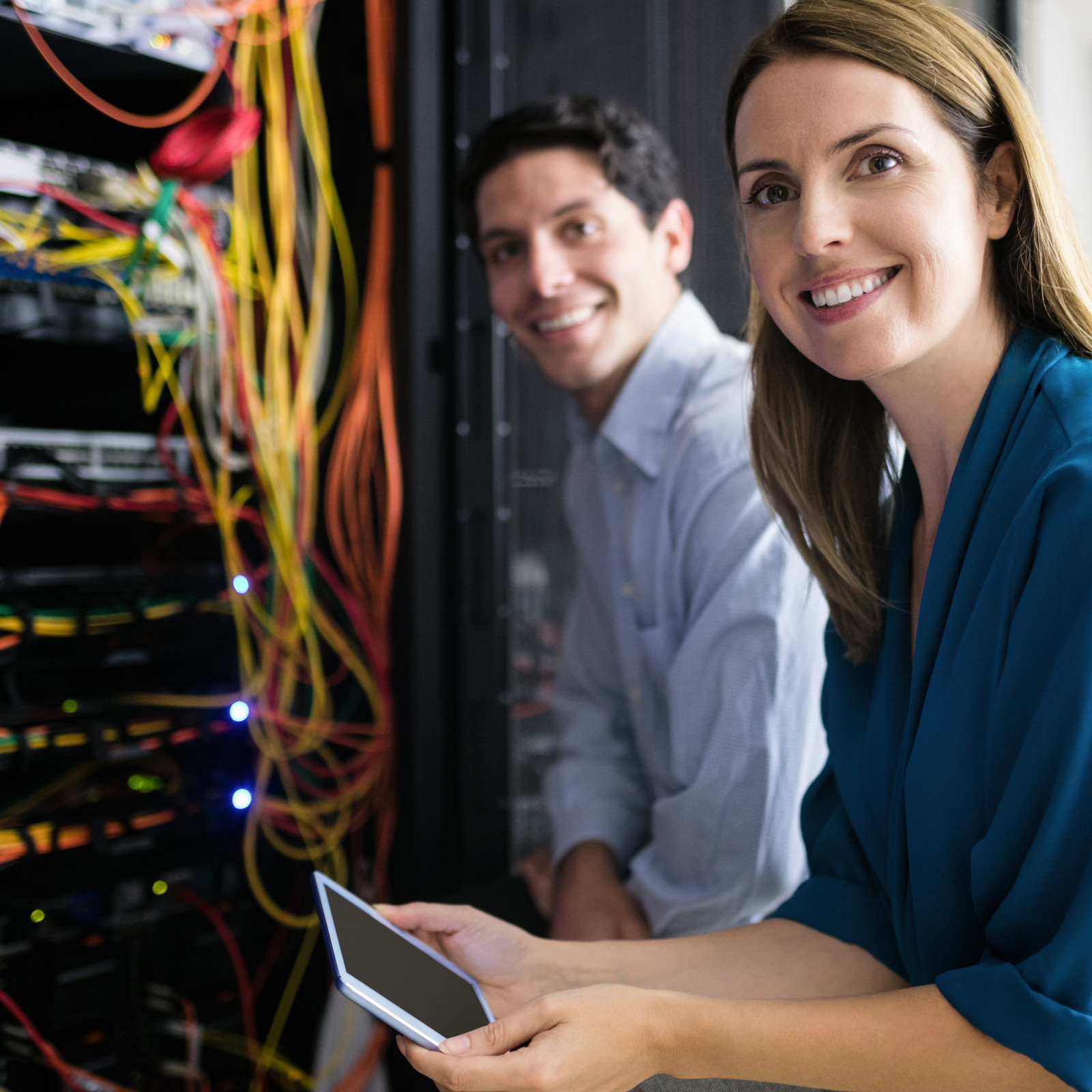 hochzwei_btnord_teaser_05.jpg Mann und Frau lächelnd vorm Server mit bunten Kabeln