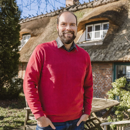 00001010 ... Mitarbeiterjubiläum vor einem Reetdachhaus